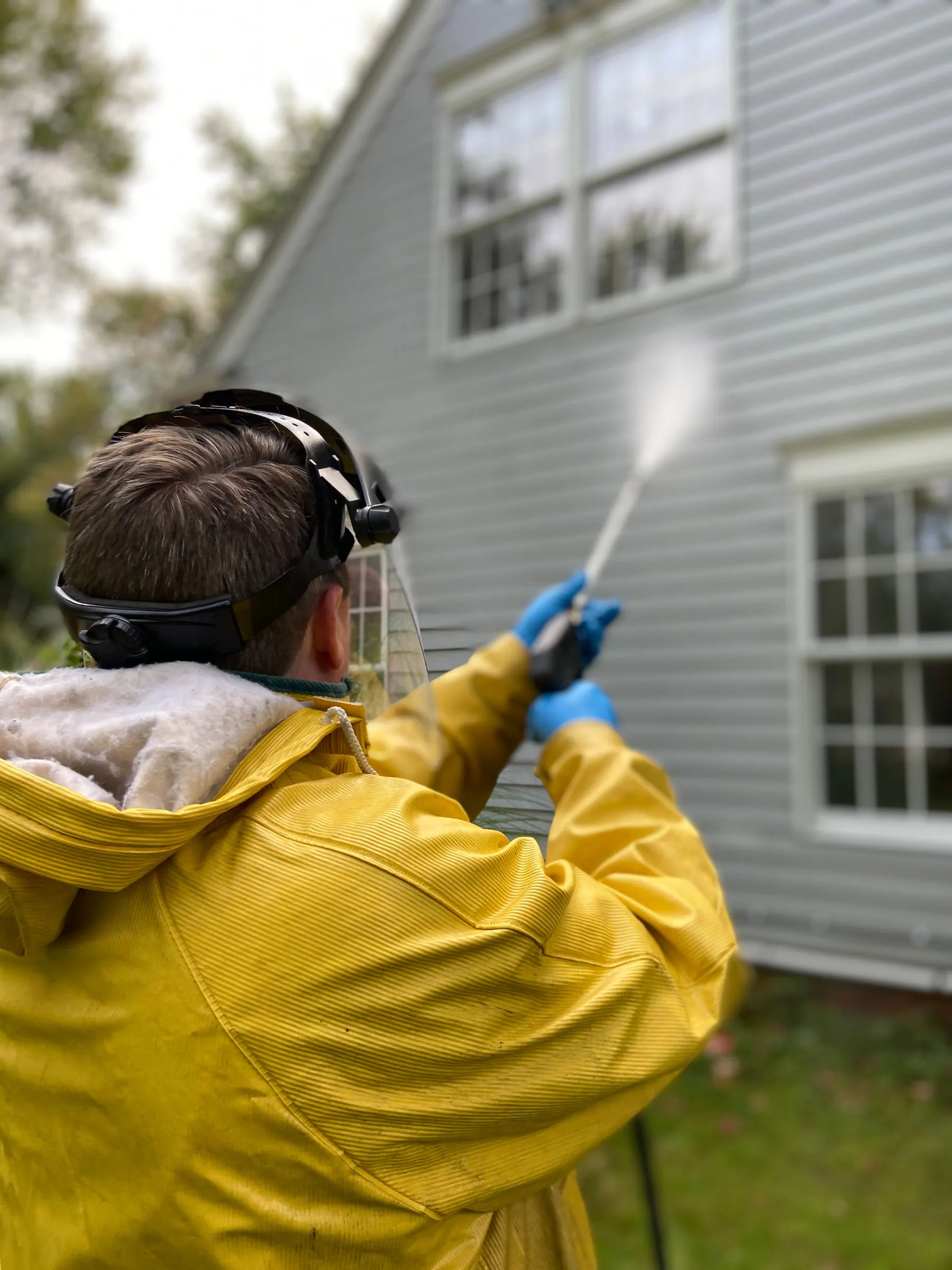 Power washing the outside wall of a house