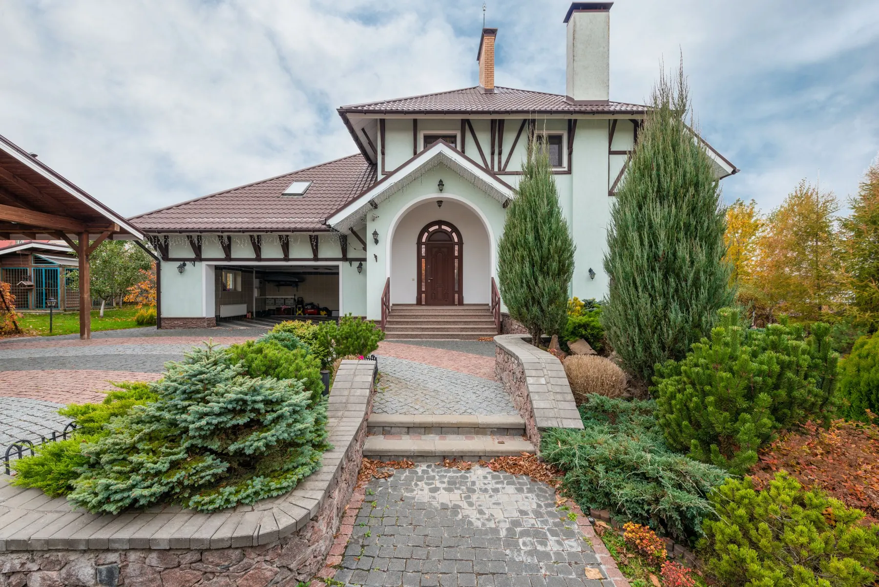 House with a brick driveway and tidy garden